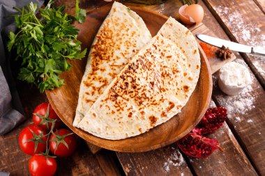 Azerbaycan ulusal mutfağı bir tabakta kutabs ile ayırt edilir. Üst görünüm ve tahta arkaplan