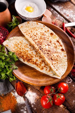 Azerbaycan ulusal mutfağı bir tabakta kutabs ile ayırt edilir. Üst görünüm ve tahta arkaplan