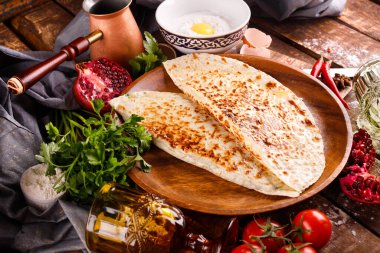 Azerbaycan ulusal mutfağı bir tabakta kutabs ile ayırt edilir. Üst görünüm ve tahta arkaplan