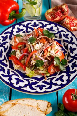 Masada taze salata, sebze ve kırmızı biber var.