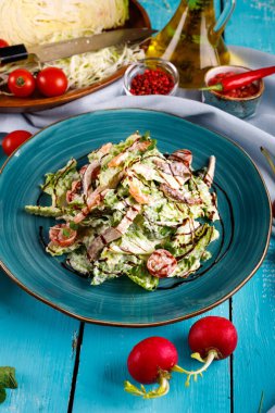 Masada karides ve pastırma salatası, marul ve domates var.