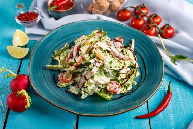 Masada karides ve pastırma salatası, marul ve domates var.