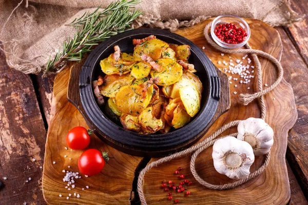 Ahşap bir tahtanın arka planında, et kaplı kızarmış patates.