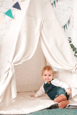 Küçük çocuk çadırın yanında oyun oynuyor. Çocuk oyuncaklarla oynuyor.