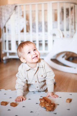 Küçük bir çocuk güzel odasında ahşap bir daktiloyla oynuyor.