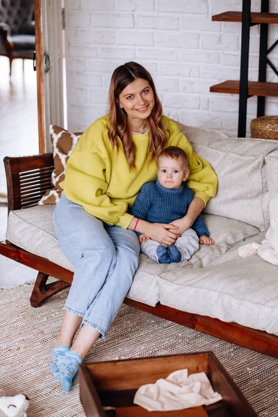 Happy mother and son are sitting on the sofa.