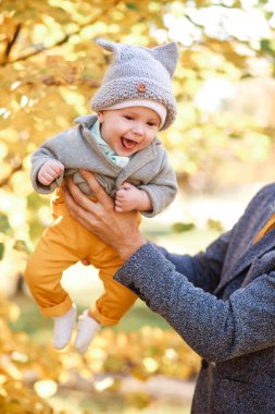 Genç bir oğul, sonbaharda doğa yürüyüşü sırasında babası tarafından tutulur.