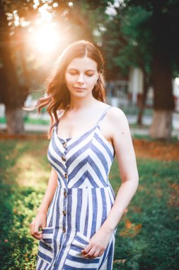 Açık havada romantik bir kızın güzelliği doğanın tadını çıkarır. Parlak saçlı, güzel bir sonbahar modeli. Gün batımında güneş ışığı..