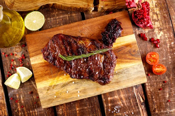 rib eye steak with margarine on a cutting Board on a wooden table background