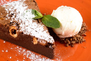 Badem ve nane dilimleri serpiştirilmiş brovniler portakal tabağına dizilmiştir. Brovniler bir çeşit çikolatalı kektir..