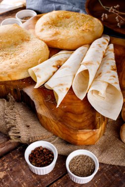 Masa arkasındaki ahşap bir tahtadaki farklı ekmek türleri