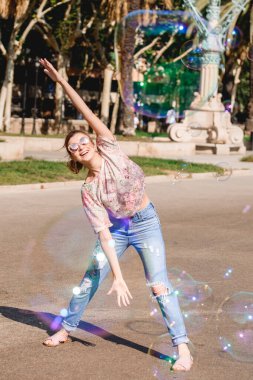 Barselona, İspanya, kız sokakta sabun köpüğüyle oynuyor ve eğleniyor.