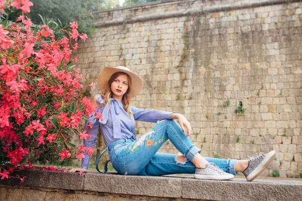 Het Meisje Naast Struiken Met Bloemen Een Hoed Een Stijlvolle — Stockfoto