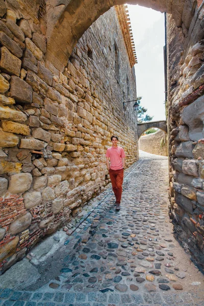 stock image A young man runs against a wall on a street in the medieval city of Carcassonne in France on a Sunny day