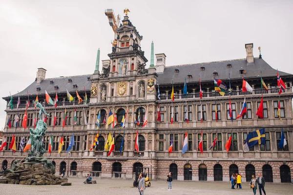 Güneşli bir günde tüm ulusların bayraklarıyla Antwerp Belediye Binası