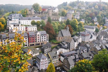 Monschau şehri ve bir tepenin tepesinden kalenin manzarası, Almanya bulutlu bir günde