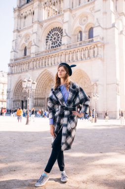 Notre Dame 'ın Paris Katedrali' nin arka planında güzel bir paltoyla mikimaus şapkalı güzel bir kız.