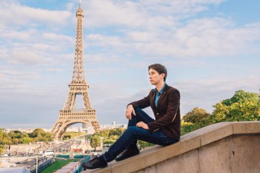 Paris, Fransa 'daki Eyfel kulesinin arka planına karşı bir adam. Kavramsal bir yolculuk.