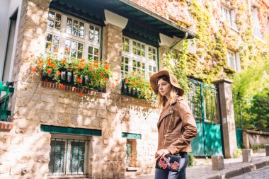 Kahverengi ceketli güzel bir kadın sabahın erken saatlerinde Paris, Fransa 'daki ünlü Montmartre tepesinde yürüyor.