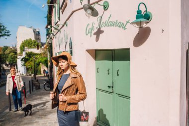 Romantik bir kız Montmartre, Paris 'te pembe bir evin önünde duruyor.