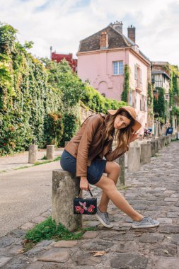 Kahverengi ceketli güzel bir kadın sabahın erken saatlerinde Paris, Fransa 'daki ünlü Montmartre tepesinde yürüyor.