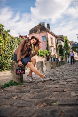 Kahverengi ceketli güzel bir kadın sabahın erken saatlerinde Paris, Fransa 'daki ünlü Montmartre tepesinde yürüyor.