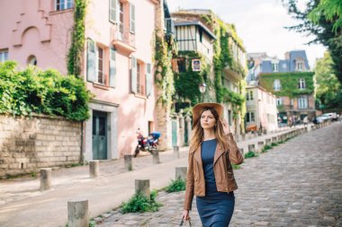 Kahverengi ceketli güzel bir kadın sabahın erken saatlerinde Paris, Fransa 'daki ünlü Montmartre tepesinde yürüyor.
