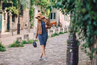 Kahverengi ceketli güzel bir kadın sabahın erken saatlerinde Paris, Fransa 'daki ünlü Montmartre tepesinde yürüyor.