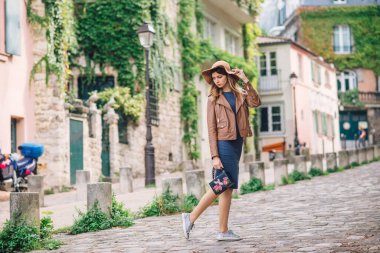 Kahverengi ceketli güzel bir kadın sabahın erken saatlerinde Paris, Fransa 'daki ünlü Montmartre tepesinde yürüyor.