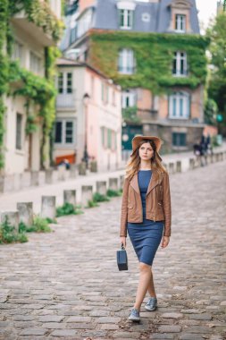 Kahverengi ceketli güzel bir kadın sabahın erken saatlerinde Paris, Fransa 'daki ünlü Montmartre tepesinde yürüyor.