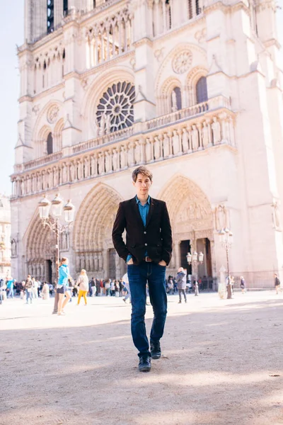 Een Jongeman Poseert Tegen Achtergrond Van Notre Dame Kathedraal Parijs — Stockfoto