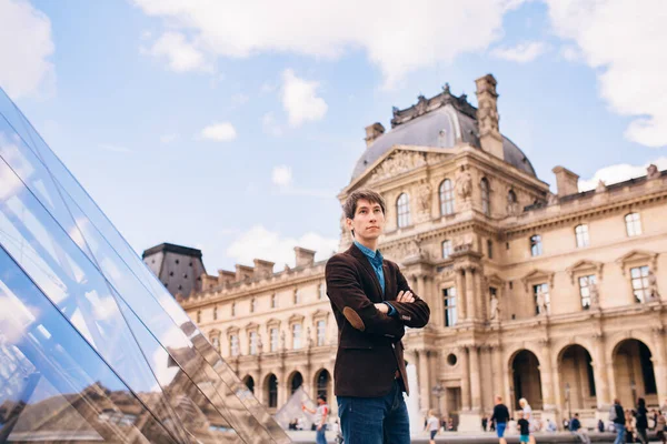 Ein Junger Mann Steht Vor Dem Hintergrund Des Louvre Gebäudes — Stockfoto