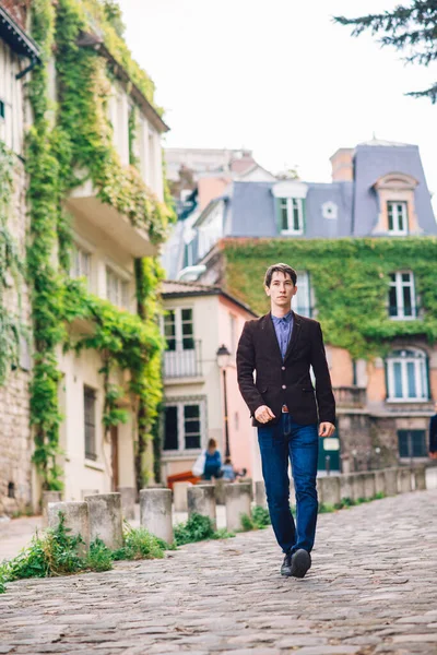 パリのモンマルトルでジャケットとジーンズを着た男が歩いている — ストック写真
