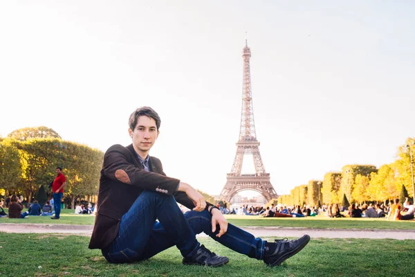 A man against the backdrop of the Eiffel tower in Paris, France. A conceptual journey.