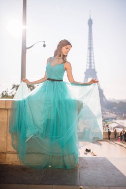 Paris 'te yeşil elbiseli bir kız yazın Trocadero meydanındaki Eyfel kulesinin arka planında zarif bir Fransız kadınının lüks ve güzel bir figürü..