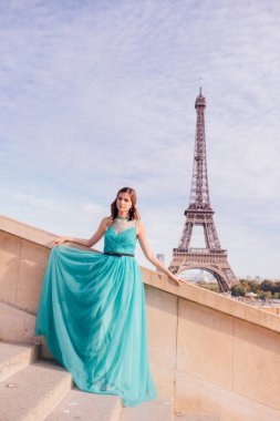 Paris 'te yeşil elbiseli bir kız yazın Trocadero meydanındaki Eyfel kulesinin arka planında zarif bir Fransız kadınının lüks ve güzel bir figürü..