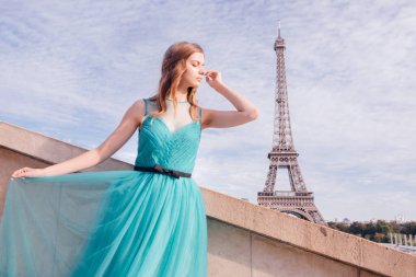 Paris 'te yeşil elbiseli bir kız yazın Trocadero meydanındaki Eyfel kulesinin arka planında zarif bir Fransız kadınının lüks ve güzel bir figürü..
