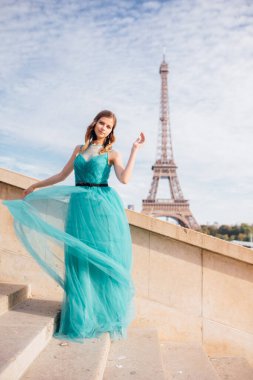 Paris 'te yeşil elbiseli bir kız yazın Trocadero meydanındaki Eyfel kulesinin arka planında zarif bir Fransız kadınının lüks ve güzel bir figürü..