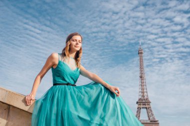 Paris 'te yeşil elbiseli bir kız yazın Trocadero meydanındaki Eyfel kulesinin arka planında zarif bir Fransız kadınının lüks ve güzel bir figürü..