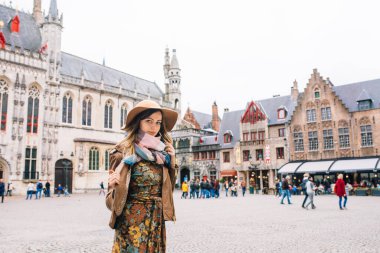 Bir kız Bruges, Belçika 'da tarihi bir binaya bakıyor.