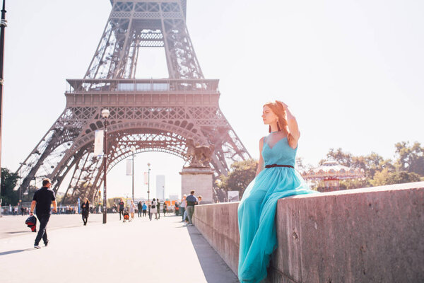 Beautiful young woman near the Eiffel tower in Paris, France