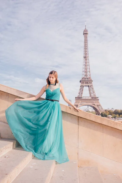 a girl in Paris in a green dress against the backdrop of the Eiffel tower elegant on the Trocadero square in summer a luxurious beautiful figure of a French woman.