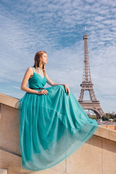 a girl in Paris in a green dress against the backdrop of the Eiffel tower elegant on the Trocadero square in summer a luxurious beautiful figure of a French woman.