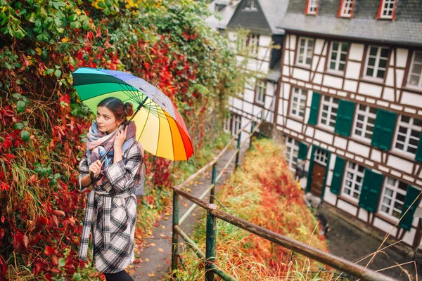 a girl in a coat walks in Monschau, Germany, despite the wet weather