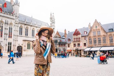 Bir kız Bruges, Belçika 'da tarihi bir binaya bakıyor.