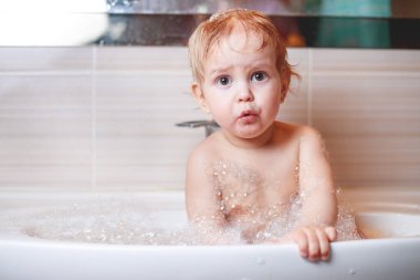 Mutlu gülen bebek bebek banyo yapıyor köpük köpüklerle oynuyor. Küçük çocuğun yıkanması ve yıkanması. Çocukların bakım ve hijyen konsepti.