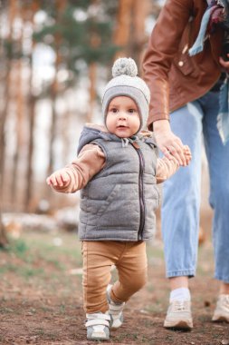 genç annenin bebeği ile oynuyor. Anne ve oğlu bir parkta yürüyüş