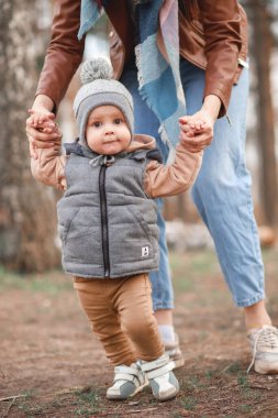 Anne ve oğlu parkta yürüyor, mutlu bir aile.