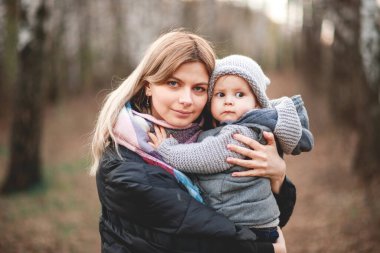 Genç bir anne ve küçük tatlı oğlu baharda parkta yürüyorlar.