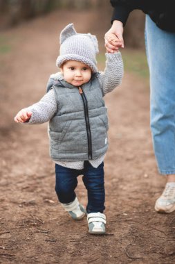 Genç bir anne ve küçük tatlı oğlu baharda parkta yürüyorlar.